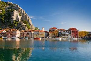 a group of buildings on the water next to a city at Apartments Ante in Omiš