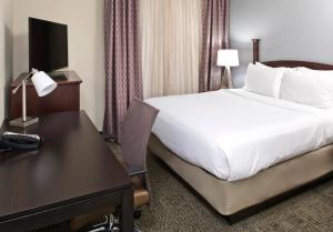 a hotel room with a bed and a desk and a bed and a desk at Staybridge Suites - Charlotte Ballantyne, an IHG Hotel in Charlotte