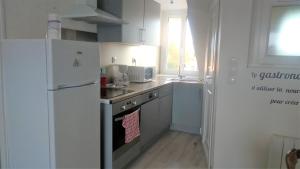 a kitchen with a refrigerator and a stove top oven at Orchidée in Berck-sur-Mer