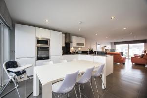 a kitchen and dining room with a white table and chairs at Atlantic Breeze in Portstewart