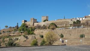 a castle on top of a hill with a road at Casa da Aldeia in Monsaraz