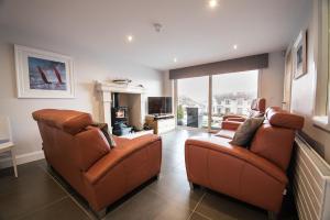 a living room with two chairs and a television at Atlantic Breeze in Portstewart