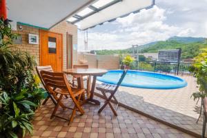a patio with a table and chairs and a swimming pool at Sam'S VIP Hostel San Gil in San Gil