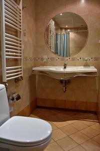 ein Badezimmer mit einem Waschbecken, einem WC und einem Spiegel in der Unterkunft Spa Villa Galileev in Welingrad