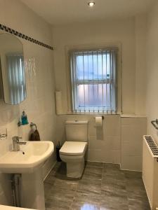 a white bathroom with a toilet and a sink at No 5 - LARGE 1 BED NEAR SEFTON PARK AND LARK LANE in Liverpool