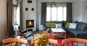 a living room with a couch and a table and chairs at Diaselo 1500m in Samarina