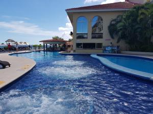 a swimming pool with blue water in a resort at Suite frente al Mar in Cancún