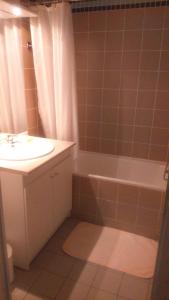 a bathroom with a sink and a tub and a shower at Appartement T2 Jardins de Ramel in Luchon