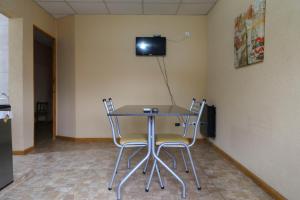 une table avec deux chaises et une télévision murale dans l'établissement Singlar Consultora, à Malargüe
