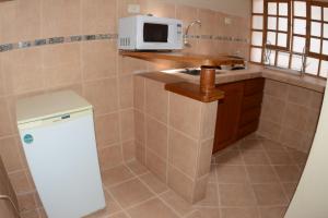 uma pequena cozinha com um lavatório e um micro-ondas em Departamentos Cusco em Cusco