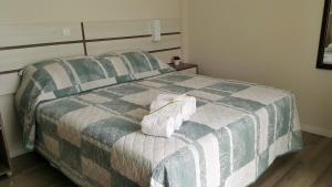 ボンビーニャスにあるPousada Bomar Bombinhasのベッドルーム1室(ベッド1台、タオル2枚付)