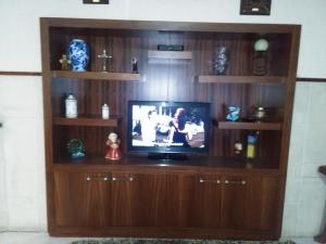 einen TV in einem hölzernen Entertainment-Center in der Unterkunft Hotel Palmeira in Aveiro
