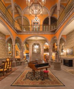 une grande salle avec un piano au milieu dans l'établissement Hotel Museo Palacio de San Agustin, à San Luis Potosí