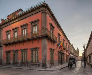 una carrozza trainata da cavalli parcheggiata di fronte a un edificio di Hotel Museo Palacio de San Agustin a San Luis Potosí