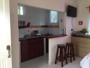 een keuken met een wastafel en 2 barkrukken bij Miss Margaritas´s House in San Andrés