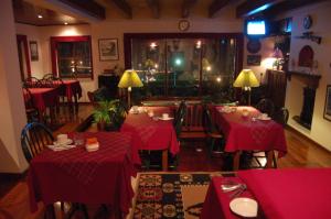 a restaurant with red tables and chairs with red table cloth at Posada Fueguina in Ushuaia