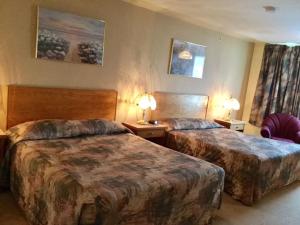 a hotel room with two beds and two lamps at Western Budget Motel #1 Grande Prairie in Grande Prairie +20 photos