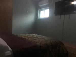 1 dormitorio con cama y ventana en Pablo Guess House en Cabo Haitiano