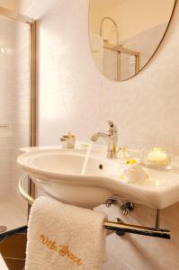 Baño blanco con lavabo y espejo en Villa Grace Tombolato, en Montesilvano
