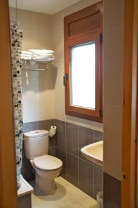 uma casa de banho com um WC, um lavatório e uma janela em Habitacions Aurora em Sant Pau de Segúries