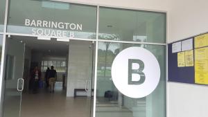 een ingang van een gebouw met een b-bord erop bij Feel Homestay in Cameron Highlands