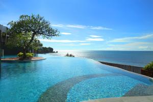 a swimming pool with a view of the ocean at Anantara Uluwatu Bali Resort in Uluwatu