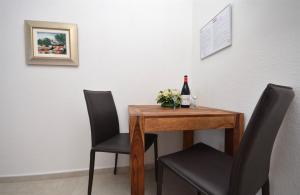 einen Tisch mit 2 Stühlen und eine Flasche Wein in der Unterkunft Apartments Mara in Vodice