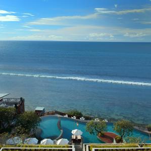 a beach with a view of the ocean and mountains at Anantara Uluwatu Bali Resort in Uluwatu
