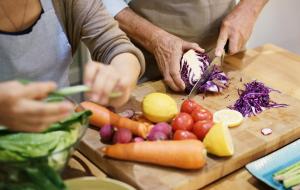 a group of people cutting vegetables on a cutting board at Anantara Uluwatu Bali Resort in Uluwatu