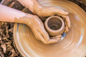 a person making a pot on a pottery wheel at Anantara Uluwatu Bali Resort in Uluwatu