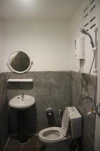 un bagno con lavandino, WC e specchio di Cottage Hill at Lanta a Ko Lanta Altre 50 foto