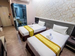 Postel nebo postele na pokoji v ubytování Indra Hotel Ipoh