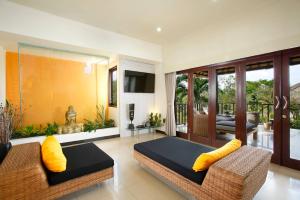 a living room with two couches and a balcony at Villa L'Orange Bali in Keramas