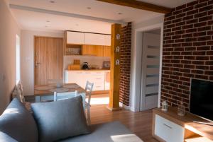 a living room with a couch and a table and a kitchen at Apartamenty Sami Swoi in Zełwągi