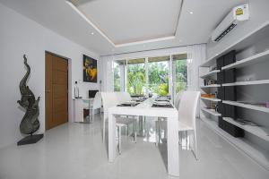 a white dining room with a white table and chairs at VILLA CHELONI 2 BEDROOMS in Kamala Beach