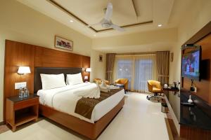 a hotel room with a bed and a flat screen tv at Southern Star,Davangere in Dāvangere