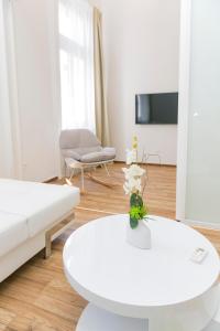 a living room with a white couch and a table at Convenience & Chic by the Basilica in Budapest