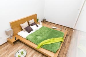a bedroom with a large bed with a green blanket at Convenience & Chic by the Basilica in Budapest