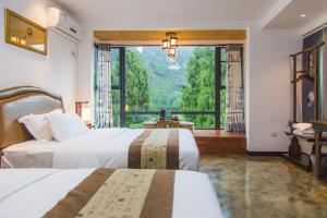 Postel nebo postele na pokoji v ubytování Leisure Courtyard Hotel Yangshuo-Free shuttle bus to Yangshuo station stay 2 nights One Way
