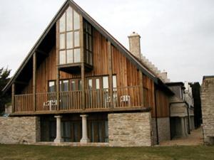 a large house with a balcony on top of it at Louisa Lodge & Purbeck House Hotel in Swanage