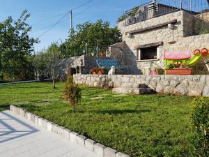 a dog sitting in a yard next to a building at House Anastazia Pool & Panoramic Sea View in Lovran