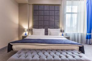a bedroom with a large bed with a large headboard at Grand Sapphire Hotel in Almaty