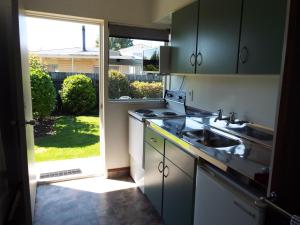 una cocina con fregadero y una puerta a un patio en Andorra Motel, en Geraldine