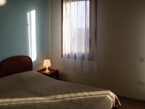a bedroom with a bed and a window with a lamp at Agriturismo Cà Vendramin in Ca Vendramin