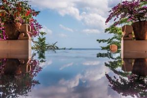 a view of the water with flowers in pots at Anantara Uluwatu Bali Resort in Uluwatu