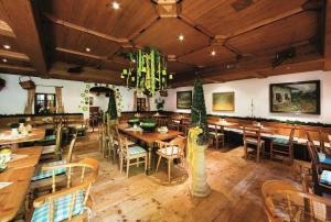 ein Restaurant mit Holztischen und -stühlen sowie einem Kronleuchter in der Unterkunft Fit Vital Aktiv Hotel DAS LUDWIG in Bad Griesbach