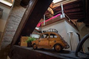 un coche viejo sentado en un estante en una habitación en Biciclo' Ferrara Città en Ferrara