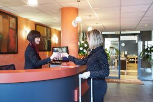 two women are standing at a counter in a store at Odalys City Lyon Bioparc in Lyon