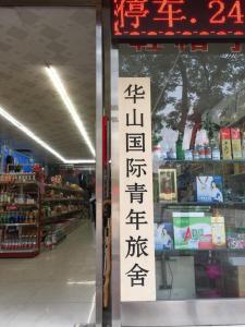 a store window with a sign in a store at Huashan International Youth Hostel in Huayin