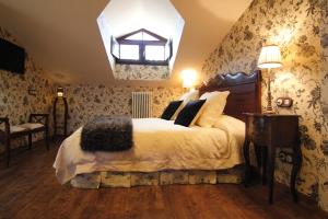 a bedroom with a large bed and a chandelier at Hotel Rural La Tenada in Carcedo de Burgos